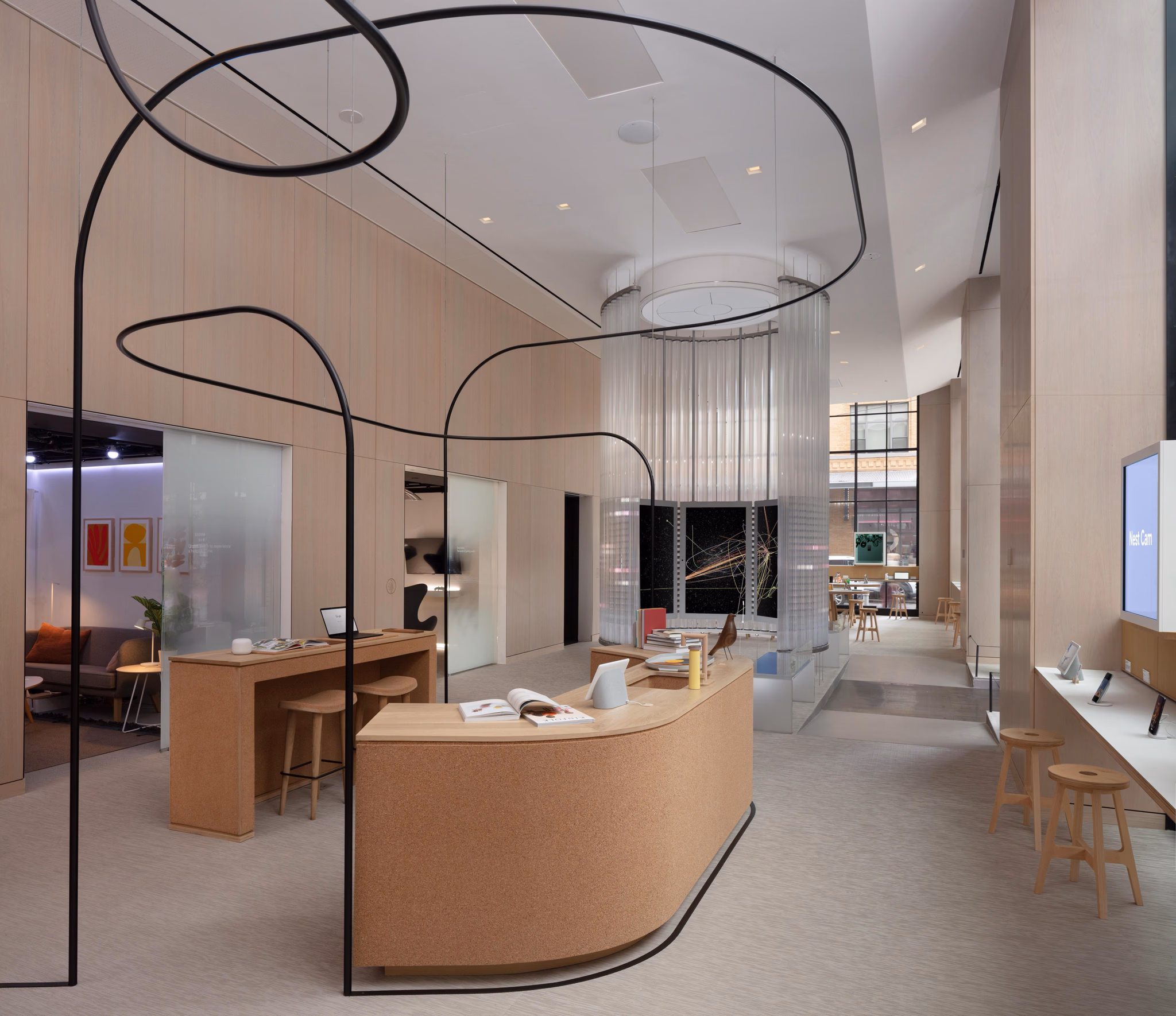 Inside the Google Store with the Imagination Space at its heart — a 17-foot-tall circular glass structure with curved interactive screens visible through the glass, surrounded by Google retail displays of phones, accessories, and a Pixel demo area